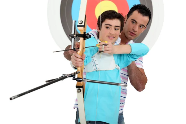 Hombre y un adolescente practicando tiro con arco — Foto de Stock