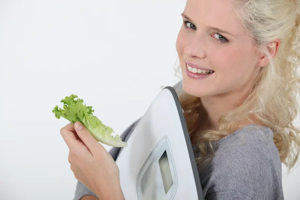 Portrait of angel-faced blonde carrying scales with salad leaf in hand — Stock Photo, Image