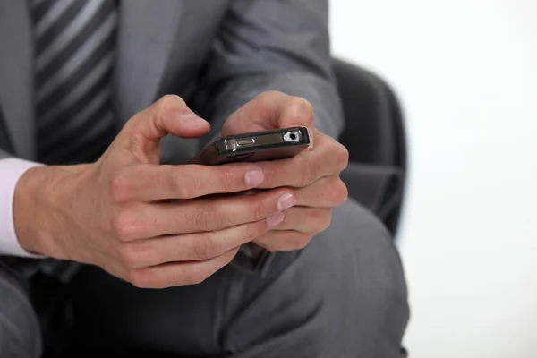 Homme d'affaires tapant sur son téléphone portable — Photo