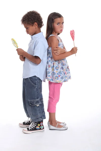 A little boy and a little girl pouting and eating ice cream — Stock Photo, Image