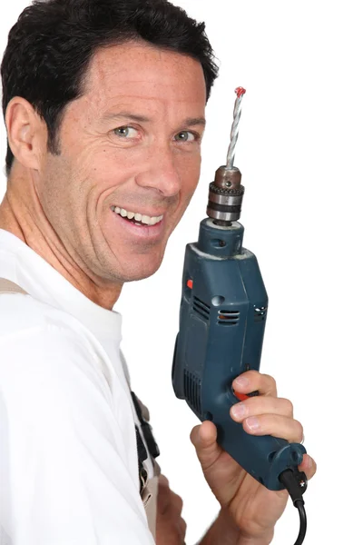 Sonriente hombre sosteniendo un taladro de energía eléctrica — Foto de Stock