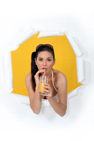 Mujer rompiendo a través de cartel bebiendo jugo de naranja —  Fotos de Stock