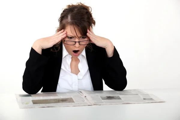 Shocked woman reading the newspaper — Stock Photo, Image