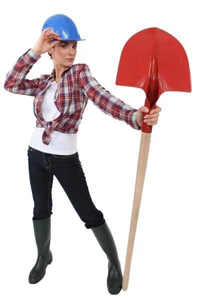 Vrouw verkleed als een arbeider poseren met een schop — Stockfoto