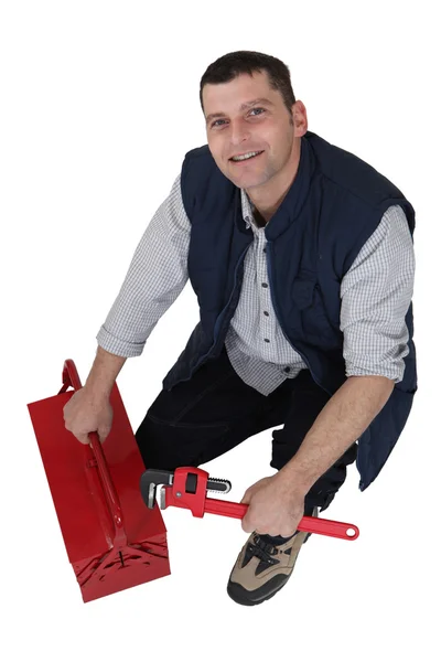 Plumber kneeling next to tool kit — Stock Photo, Image