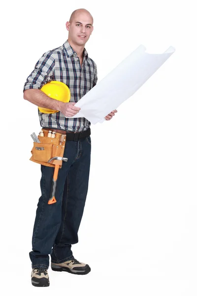 Full-length shot of carpenter consulting blueprints — Stock Photo, Image