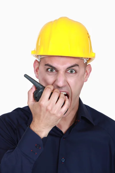 Hombre de negocios enojado con casco y gritando en un walkie talkie —  Fotos de Stock