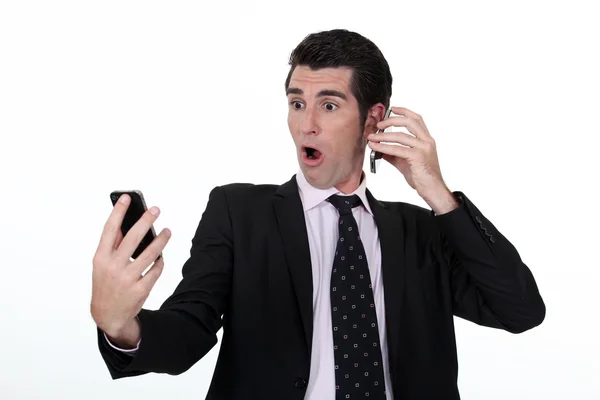 Businessman holding two cell phones — Stock Photo, Image