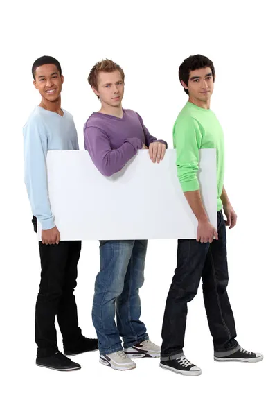 Three young men carrying a blank board Stock Photo