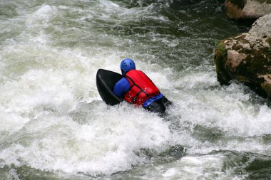 Man navigating water rapids clipart