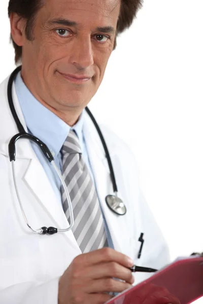 Doctor smiling with clipboard Stock Picture