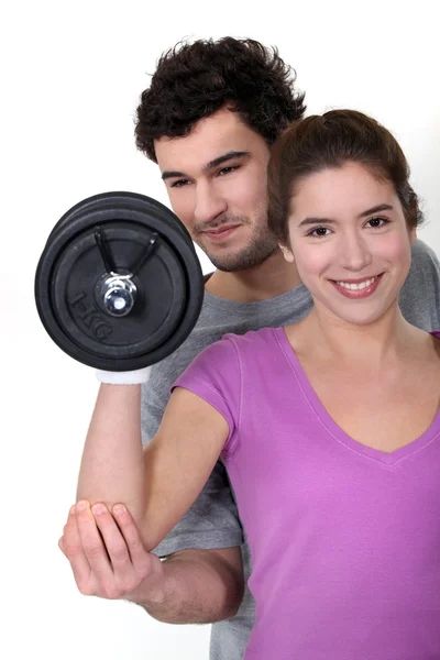 Coach and young woman all smiles lifting weight Stock Image