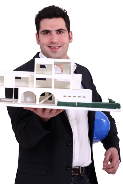 Architect holding up a building model — Stock Photo, Image