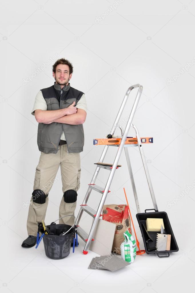 Tile fitter posing with his building materials and tools Stock Photo by