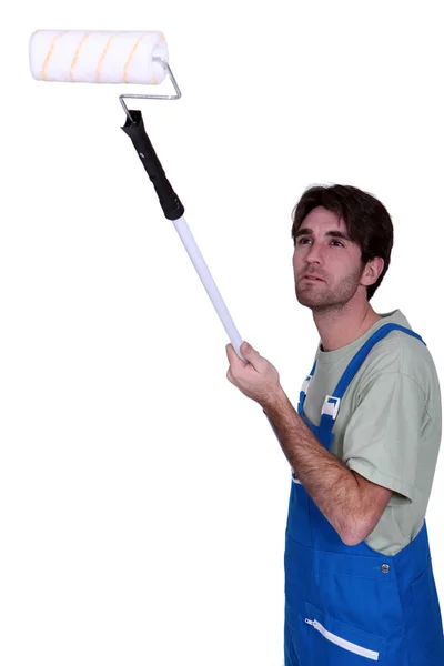 Man with an extended paint roller — Stock Photo, Image