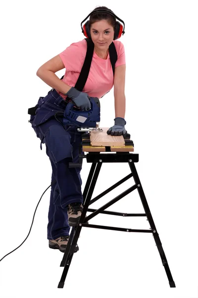 Vrouw met behulp van een elektrische jigsaw — Stockfoto