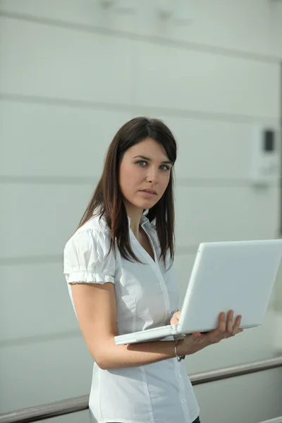 Morena de pé com laptop — Fotografia de Stock