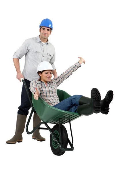 Construction couple playing with a wheelbarrow — Stock Photo, Image