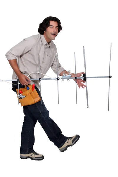 Reparador tocando guitarra ar com uma antena de televisão — Fotografia de Stock