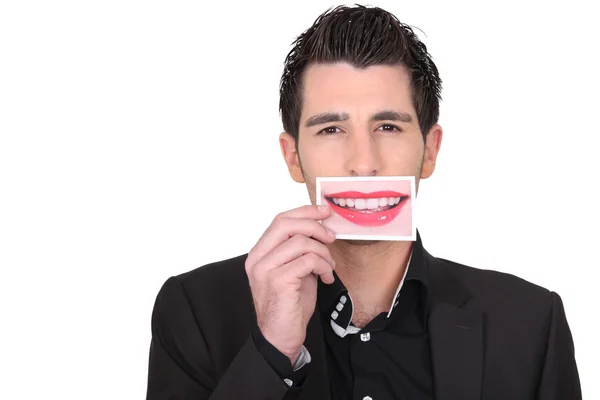 Muž v obleku drží fotografii rty na ústa — Stock fotografie