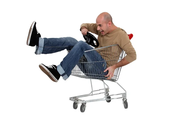 Man racing a shopping trolley — Stock Photo, Image