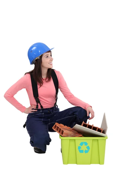 Jeune femme de métier accroupie à côté d'une poubelle de recyclage — Photo