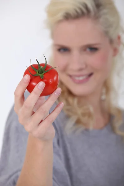 Mulher segurando um tomate maduro — Fotografia de Stock