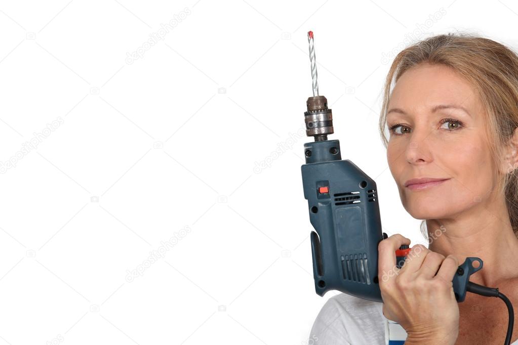 Blond woman holding electric drill.