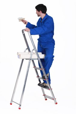 Painter in jumpsuit on ladder isolated on white clipart