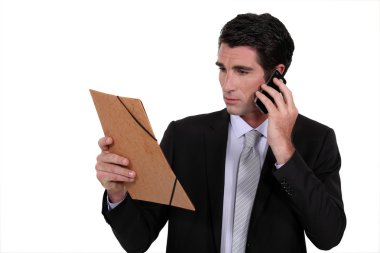Concerned businessman talking on the phone clipart