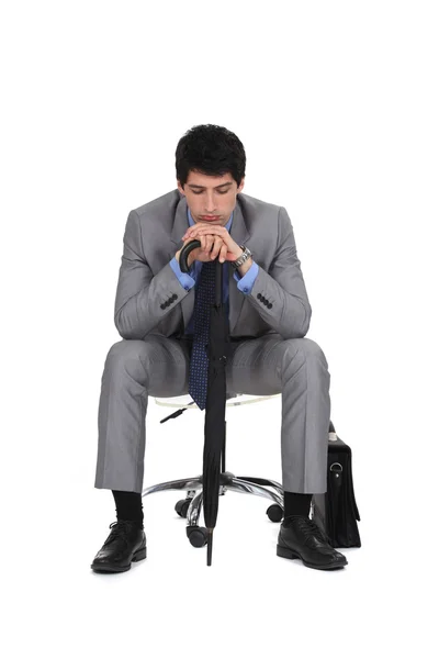 Bored businessman waiting with an umbrella — Stock Photo, Image