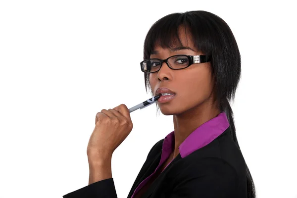 Businesswoman chewing on her pen — Stock Photo, Image