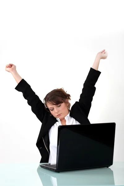Mujer de negocios estirándose en su computadora portátil — Foto de Stock