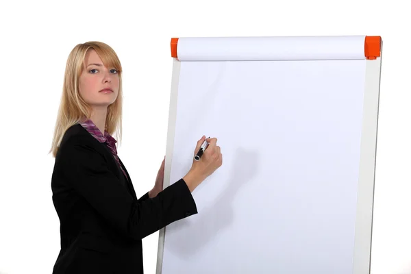 Blond businesswoman about to write on white-board Royalty Free Stock Photos