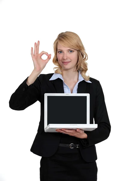 Businesswoman with laptop giving the OK signal — Stock Photo, Image