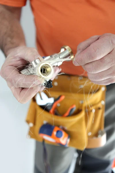 Worker winding hemp cord around a connection — Stock Photo, Image