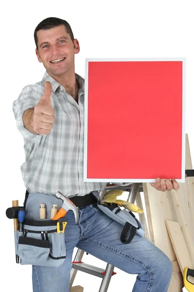 Carpenter stood by ladder giving the thumbs-up — Stock Photo, Image