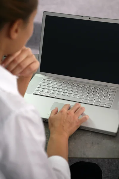 Utilizzando un computer portatile schermato in bianco su una scrivania — Foto Stock