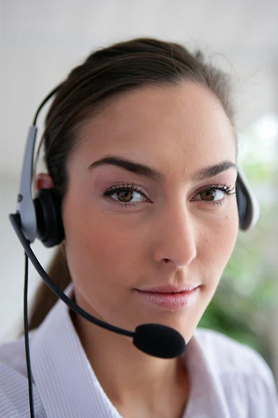 Mulher usando um fone de ouvido — Fotografia de Stock