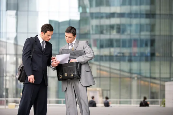 Dos hombres de negocios revisando un documento — Foto de Stock