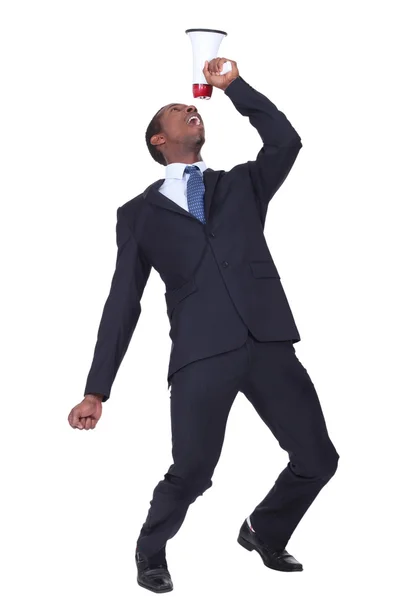 Businessman shouting into speaker phone — Stock Photo, Image