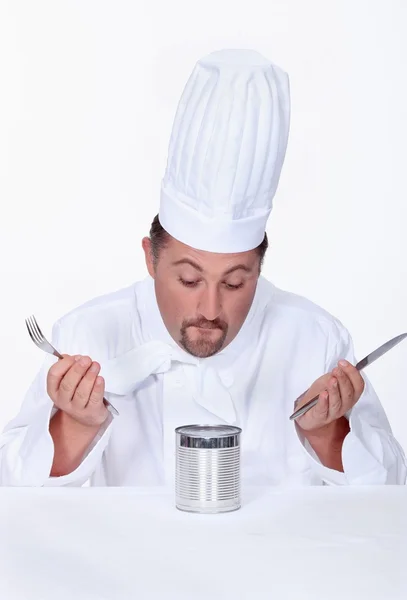 Chef olhando para uma lata de comida — Fotografia de Stock