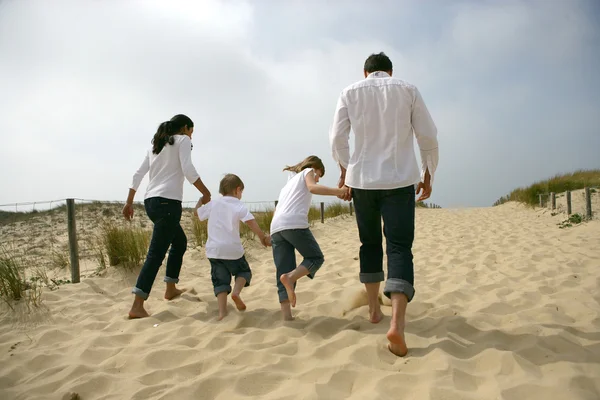 Familie spaziert am Sandstrand entlang — Stockfoto