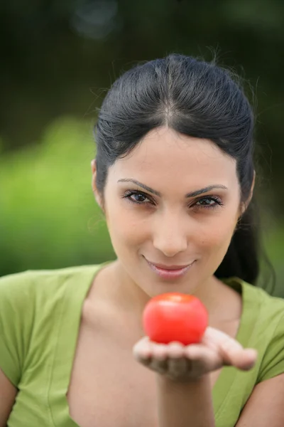 Mulher segurando um tomate — Fotografia de Stock