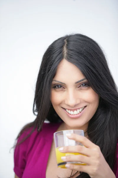 Mulher com um copo de suco de laranja — Fotografia de Stock