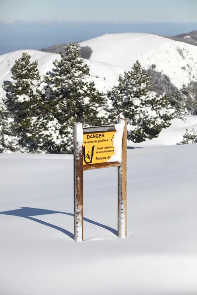 Panneau d'avertissement sur montagne enneigée — Photo