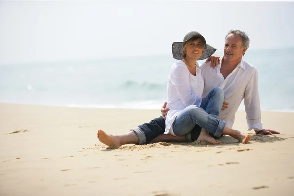 夫妇俩坐在沙滩上 — 图库照片