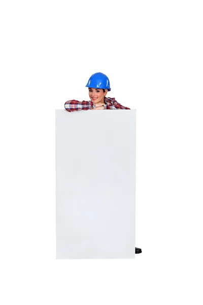 Female builder standing by advertising — Stock Photo, Image