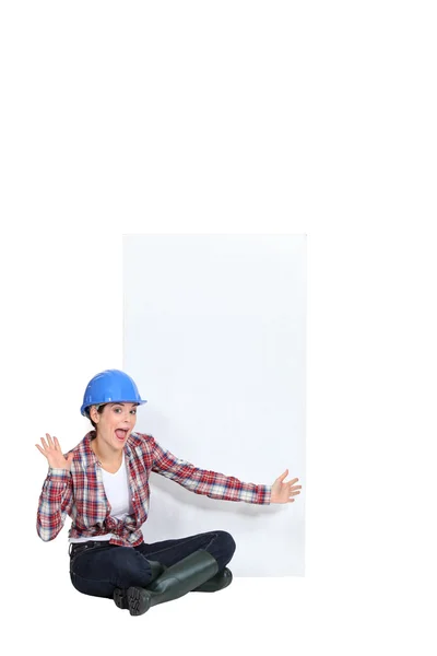 Expressive female construction worker with a blank board — Stock Photo, Image
