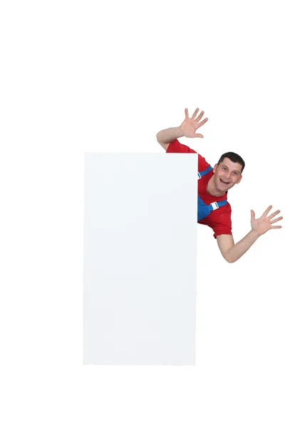 Man leaping from behind blank poster — Stock Photo, Image